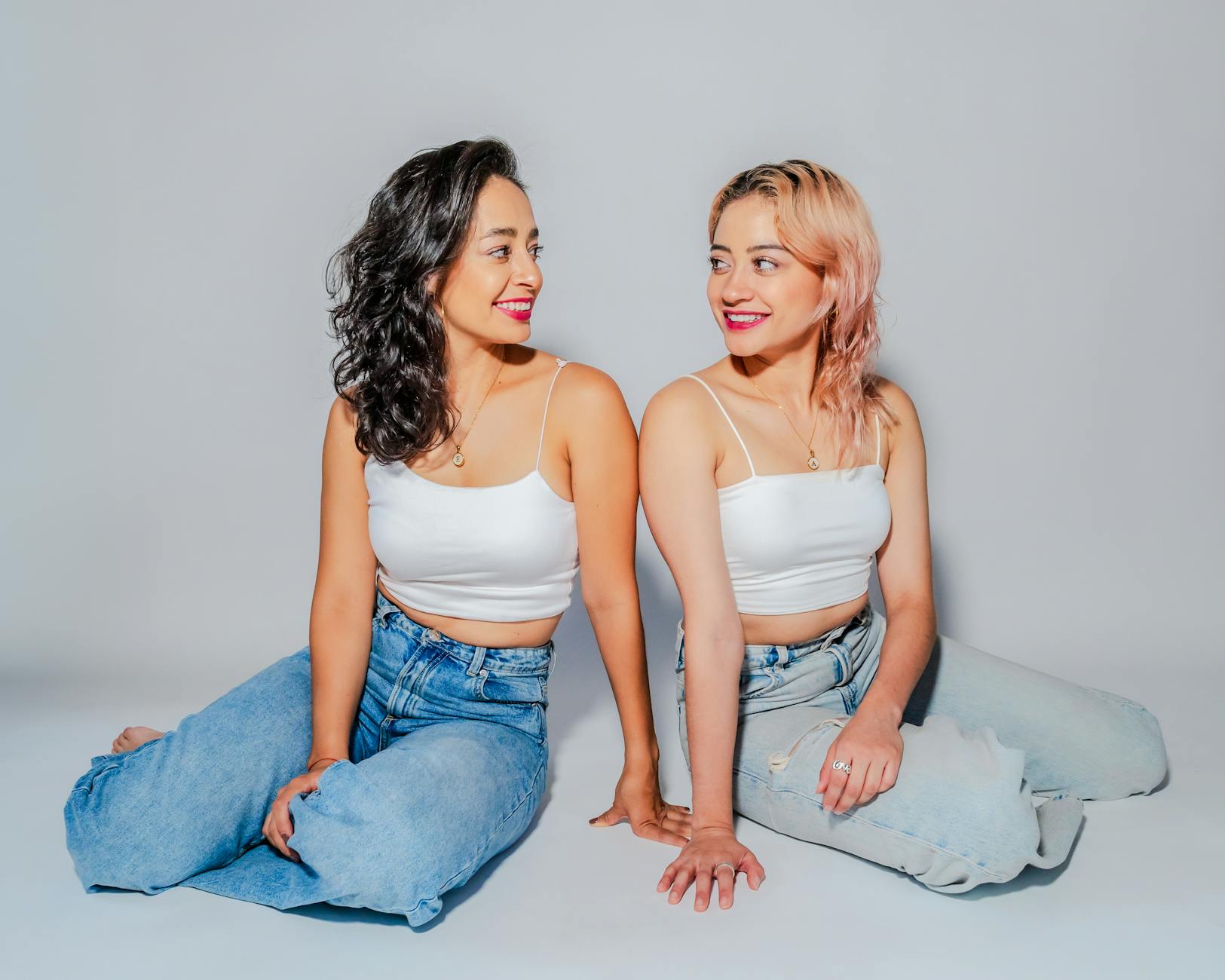 deux femmes se regardent, sourient, et partagent un bon moment de sororité et de soutient.
